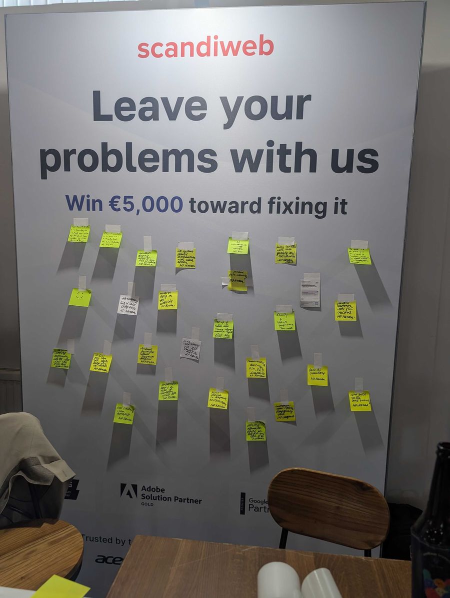 Event booth banner reading Leave your problems with us, covered in sticky notes written by visitors